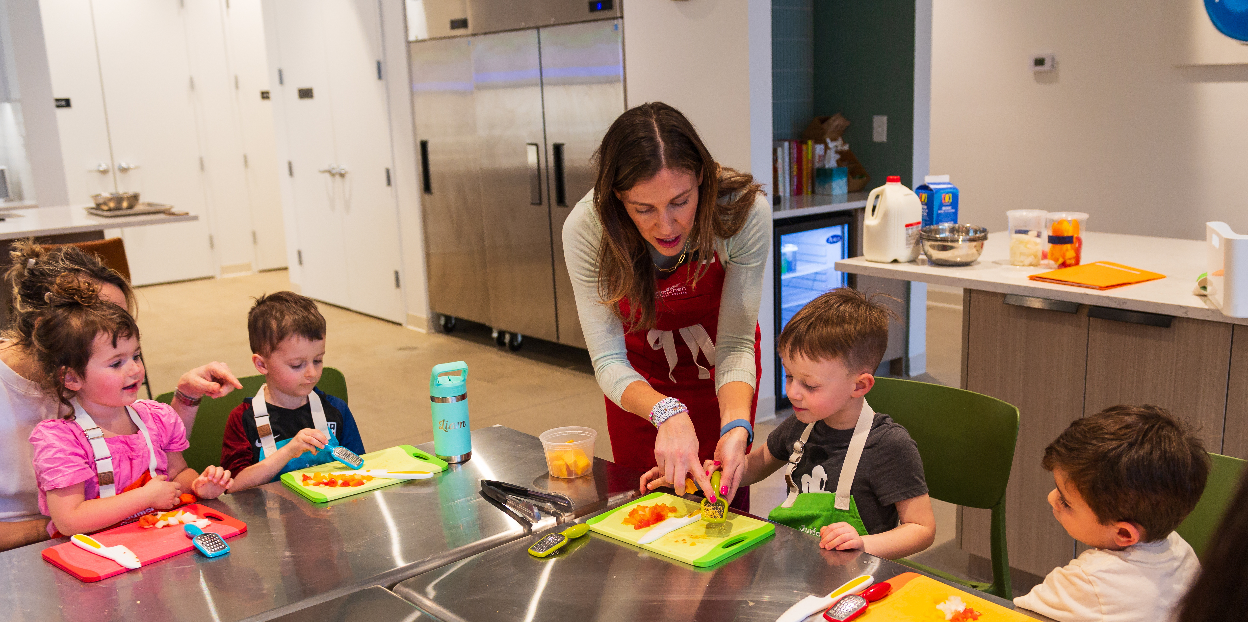 Owner Niki Cordell shows student how to use cheese grater 